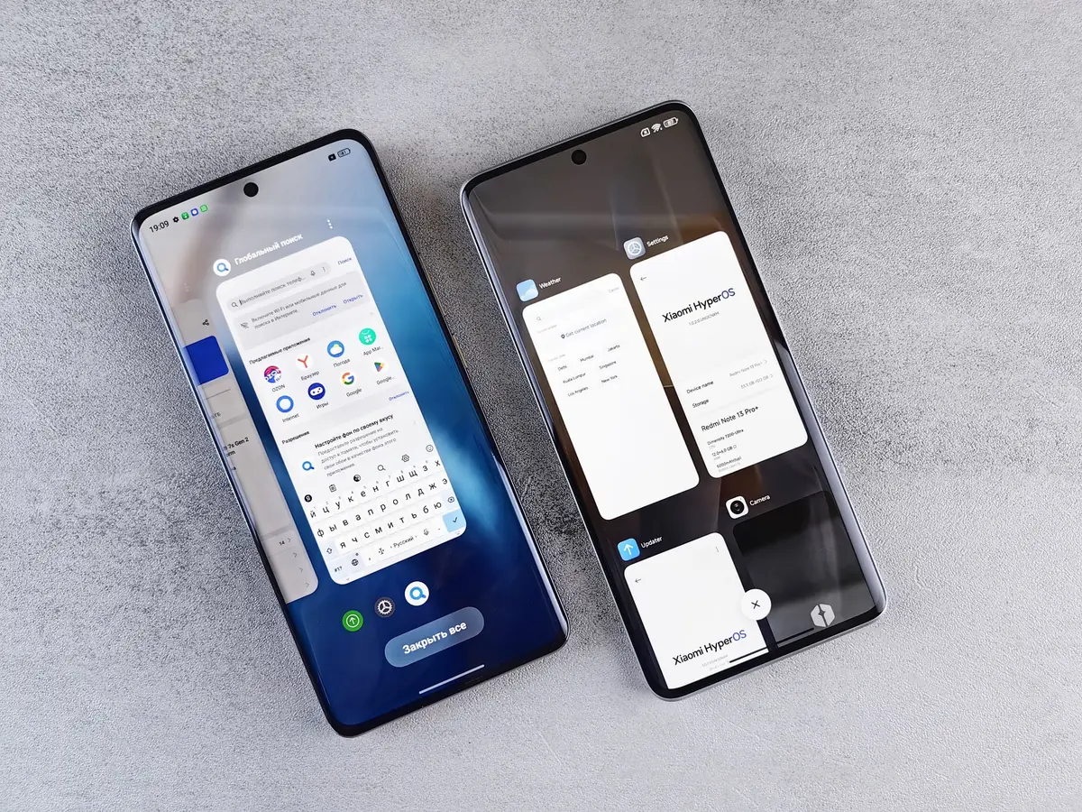 Two smartphones lying side by side on a grey surface, each showing a different app layout